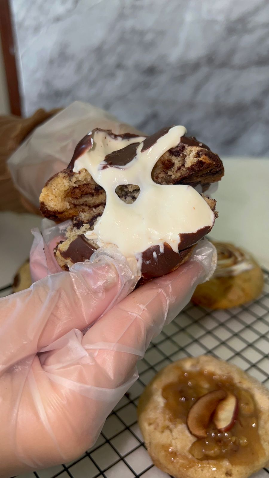 Cookie artesanal aberto mostrando recheio cremoso de chocolate e ganache branca