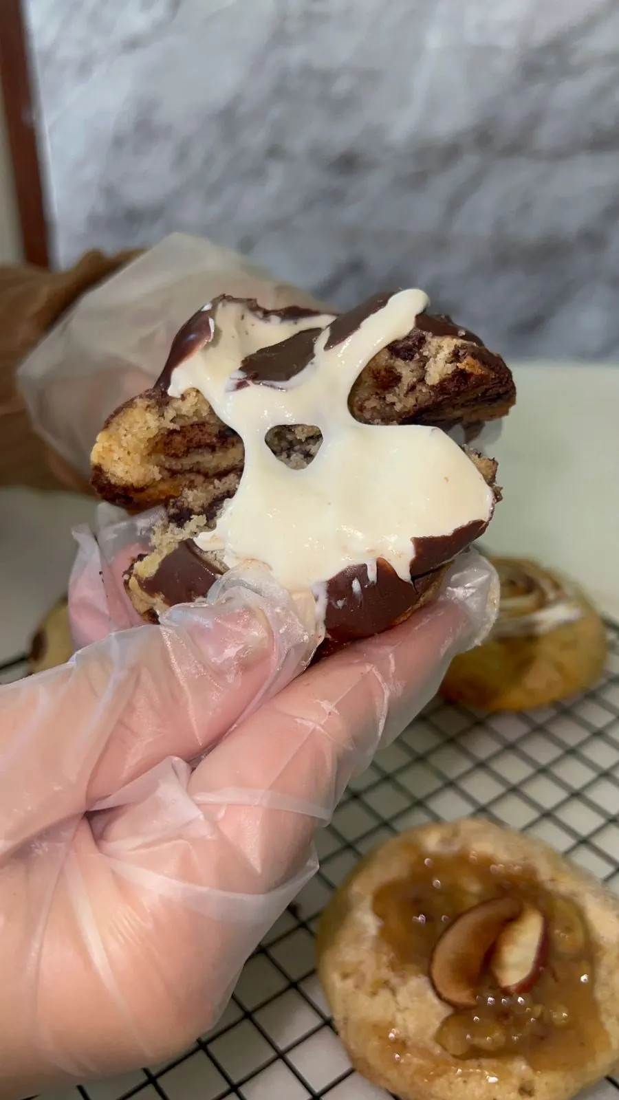 Cookie artesanal aberto mostrando recheio cremoso de chocolate e ganache branca
